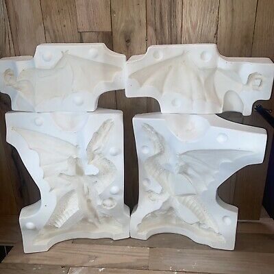 two white marble vases sitting on top of a wooden table