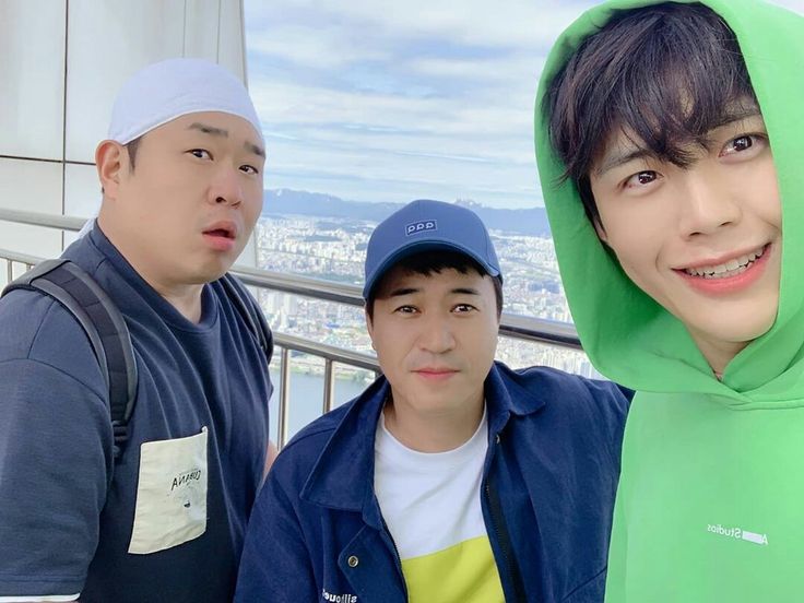 three young men standing next to each other in front of a cityscape background