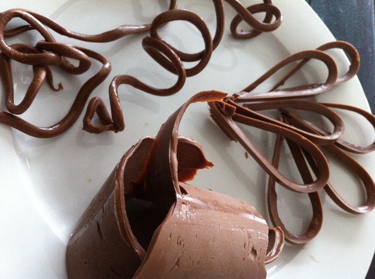 chocolate is being poured into a bowl with the inside of it's mouth open