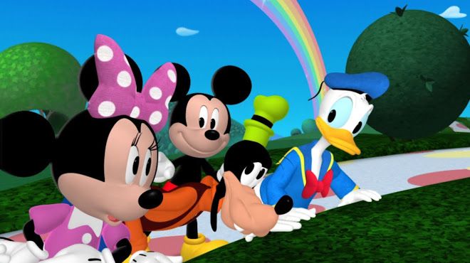 several mickey mouses are lined up on the side of a road with a rainbow in the background