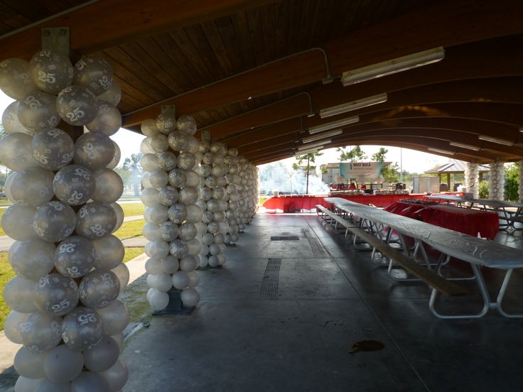 there are many tables and benches under the tent with white plastic bags on them,