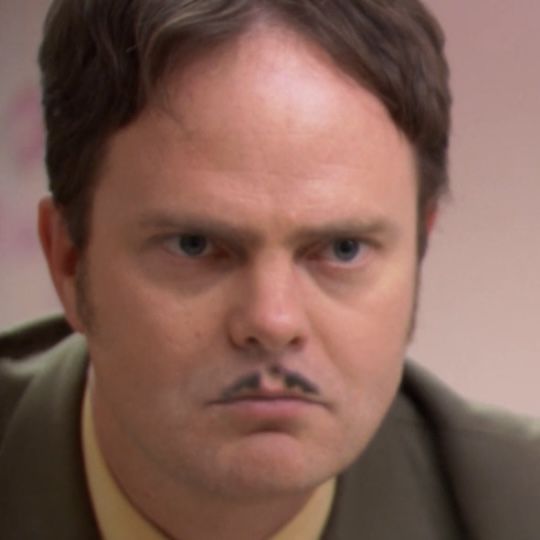 a man in a suit and tie looking at the camera with a serious look on his face