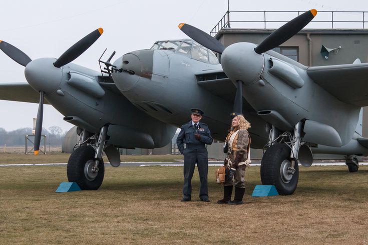 two people standing in front of an airplane