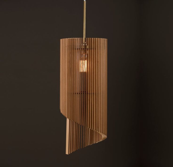 a wooden light fixture hanging from the ceiling in a dark room with black walls and flooring