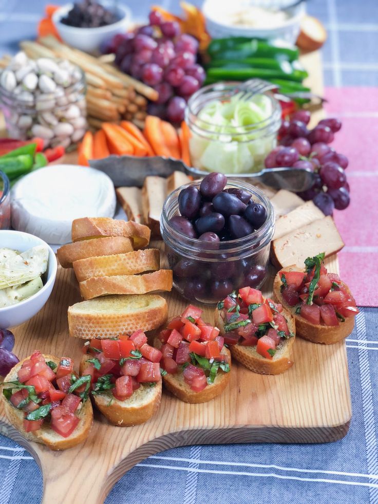 a wooden cutting board topped with lots of different types of food on top of it