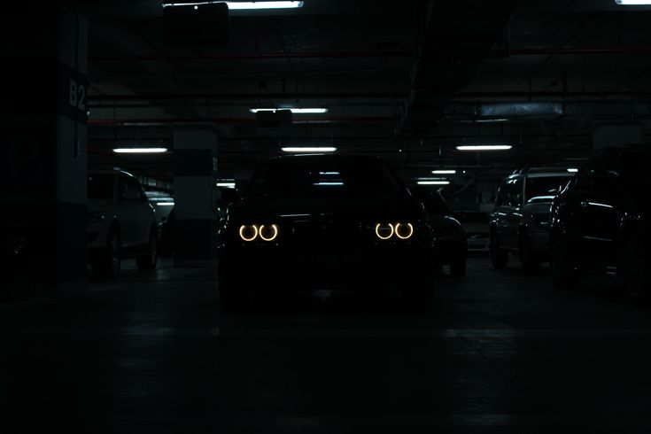 a car is shown in the dark with its headlights turned on and it's lights glowing