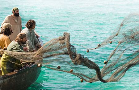 a group of people in a boat on the water with a net attached to it