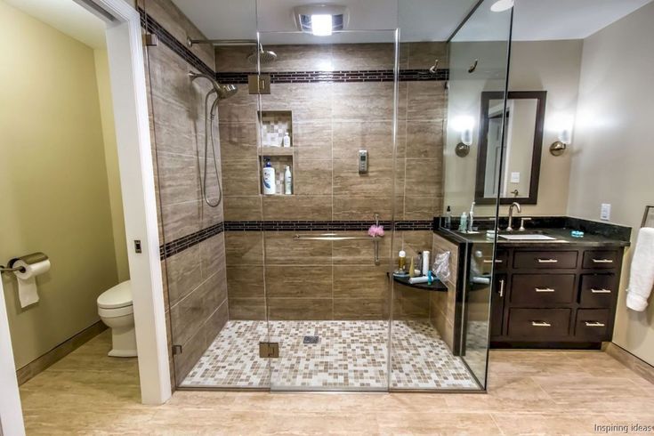 a bathroom with a walk in shower next to a toilet and sink under a mirror