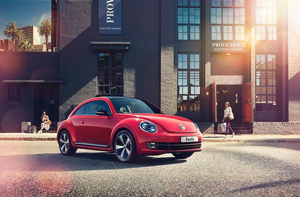 a red volkswagen beetle parked in front of a building