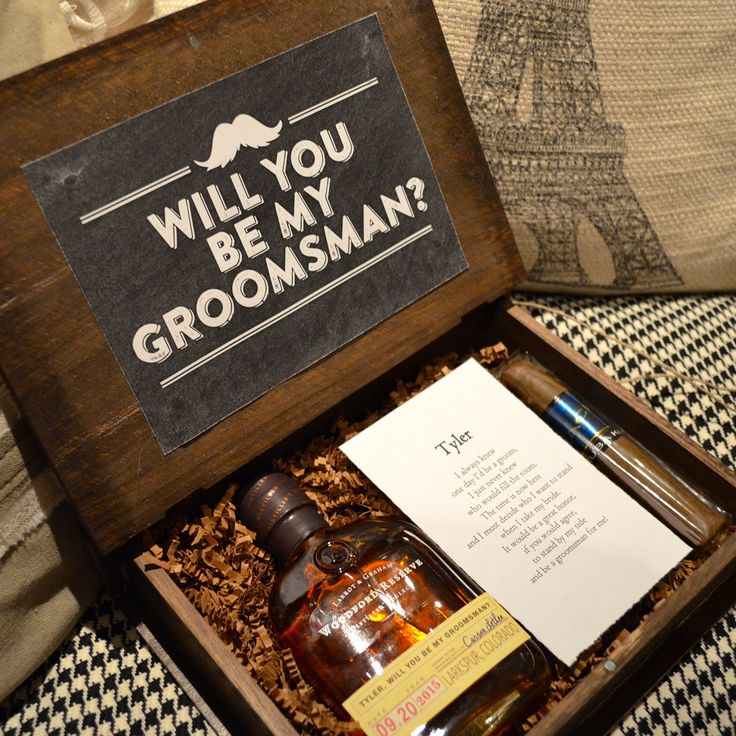 an open wooden box containing groomsmen items on a bed with the words will you be my groomsman?