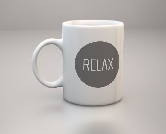 a white coffee mug with the word relax on it