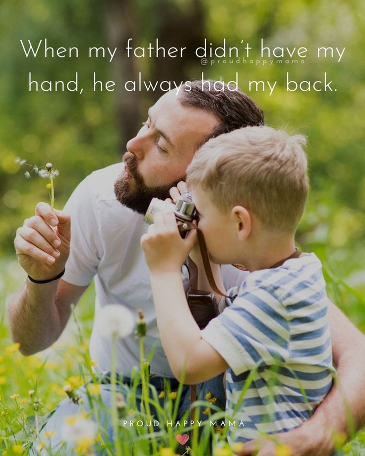 a father and son are sitting in the grass with dandelions on their fingers