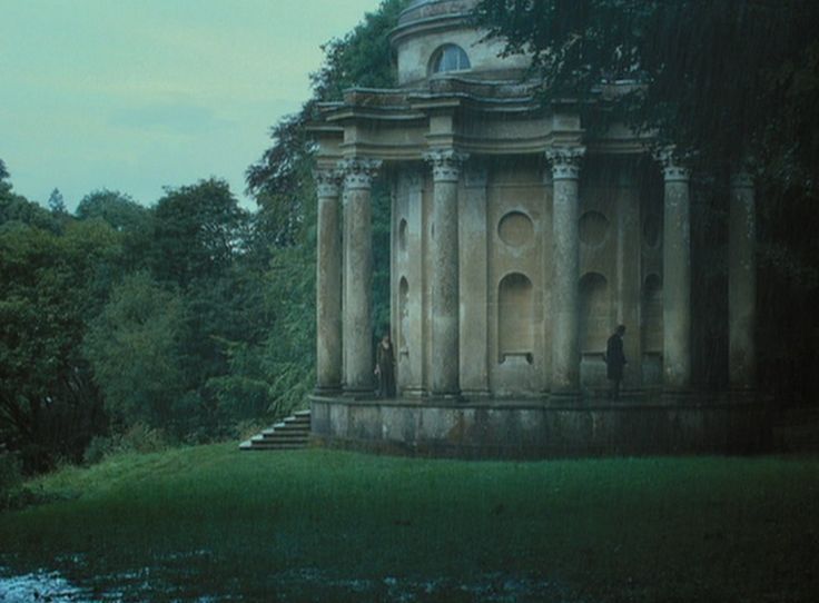 an old stone structure sitting in the middle of a forest