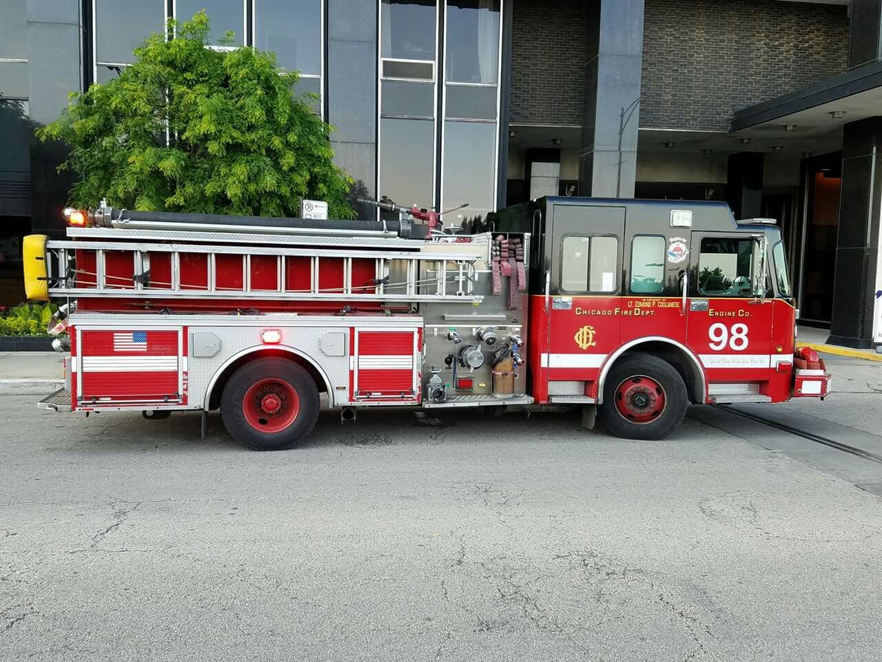 a red fire truck parked in front of a tall building