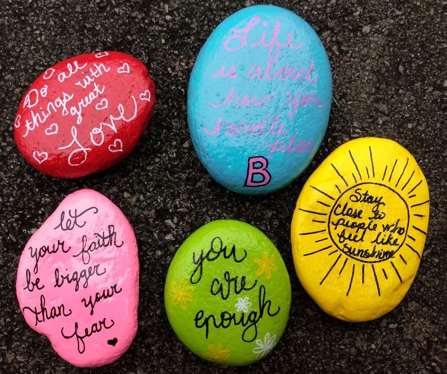 four painted rocks with different sayings and phrases on them, sitting ...