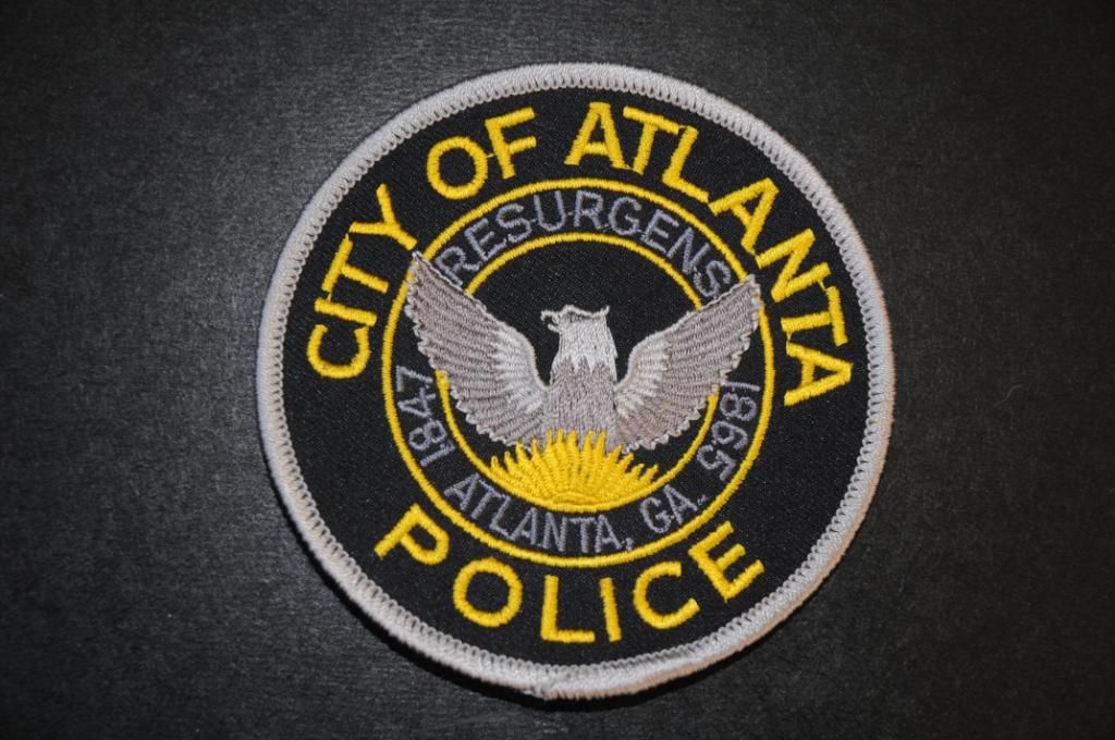 the city of atlanta police badge on a black surface with yellow and ...