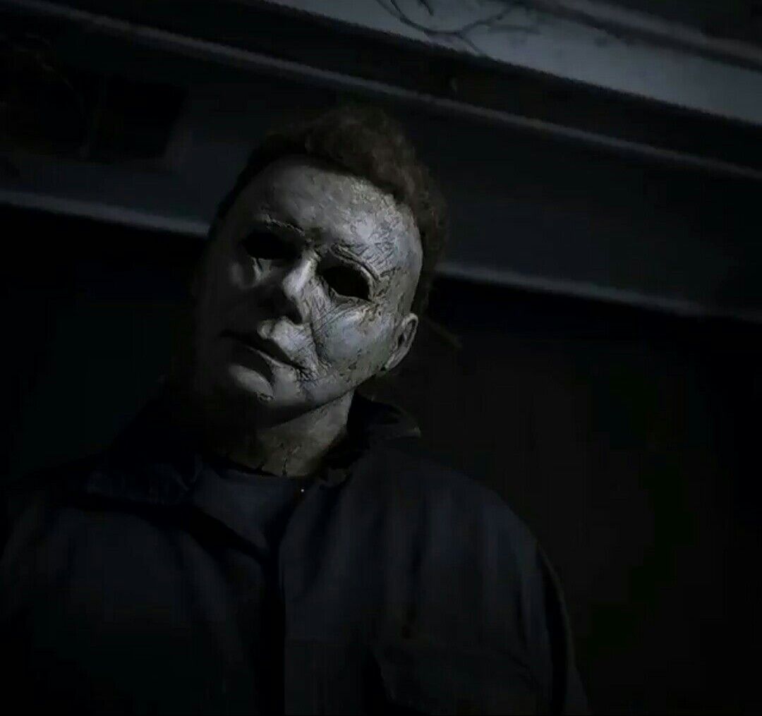 a man in a black shirt wearing a creepy mask