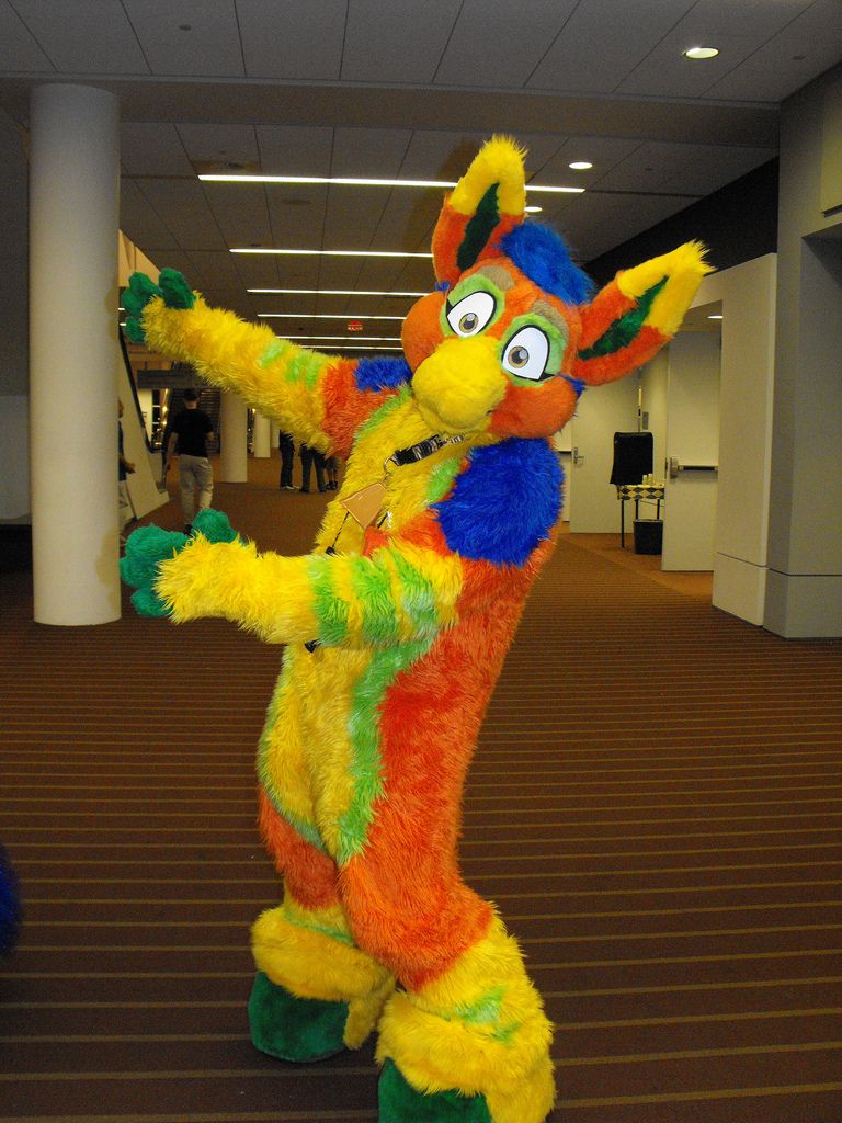 a person in a colorful costume standing on one leg and arms out to the side