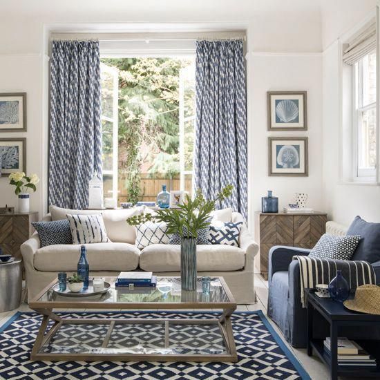 a living room with blue and white decor on the walls, couches, coffee ...