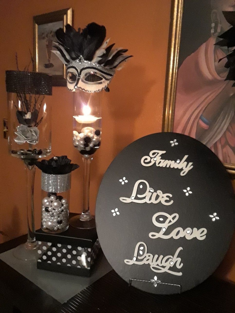 a black and white sign sitting on top of a table next to a vase filled ...