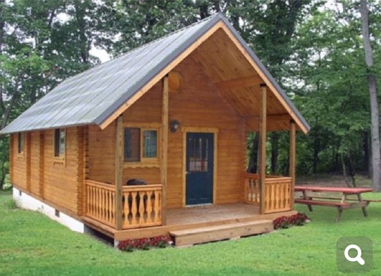 a small wooden cabin with porch and picnic table