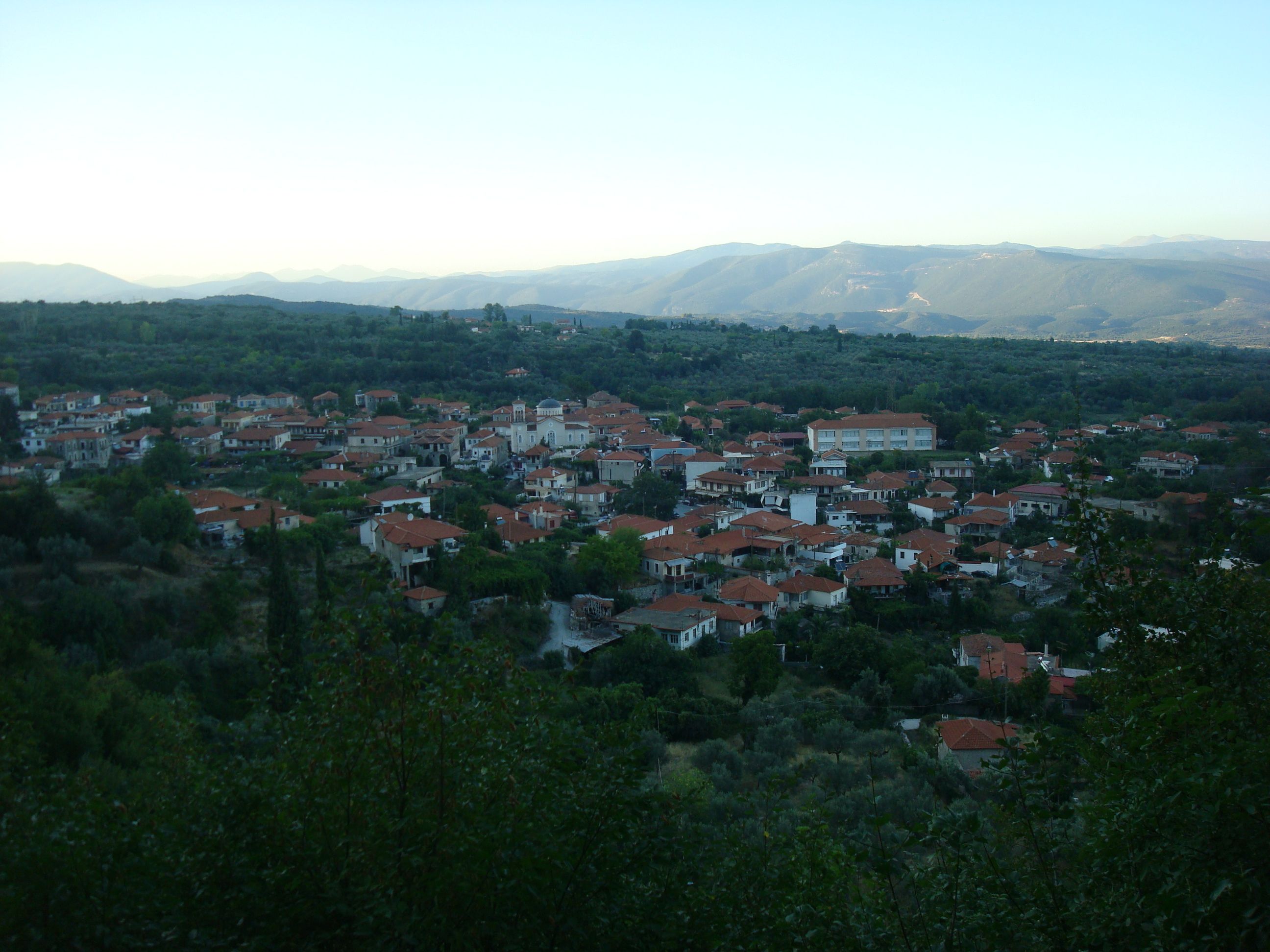 an aerial view of a small town with mountains in the background