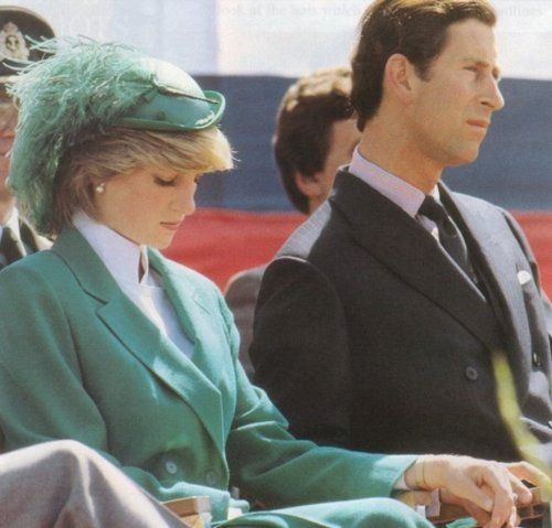 Prince Charles and his wife Princess Diana holding hands at an event ...