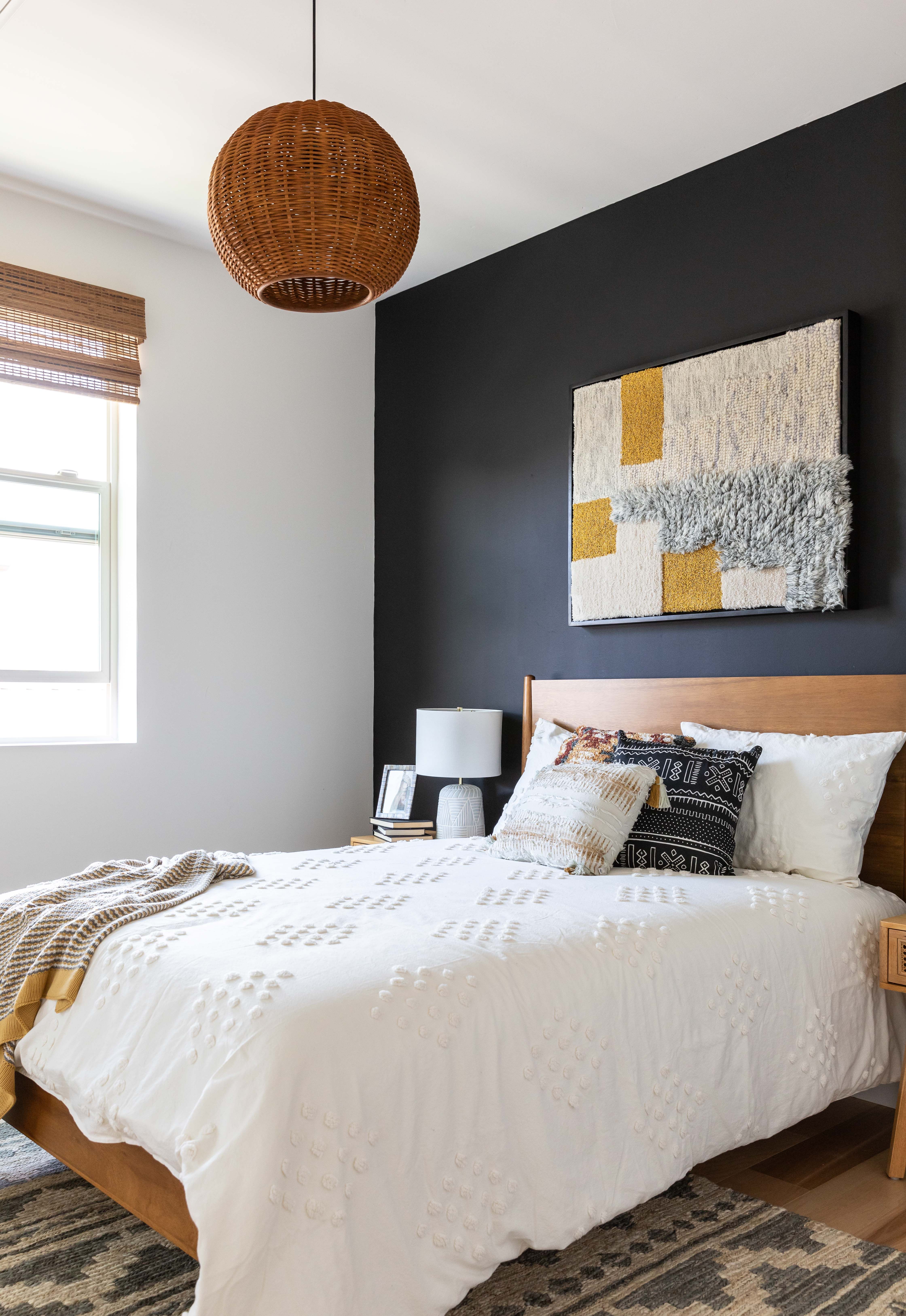 Boho Bedroom Design with Black Accent Wall and Woven Light Fixture