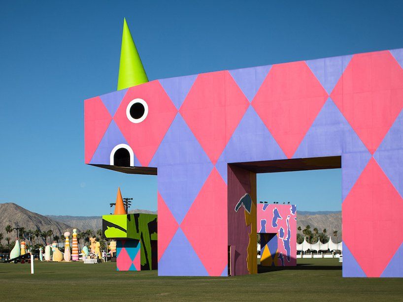 a large pink and purple building with a green hat on it's head in the ...