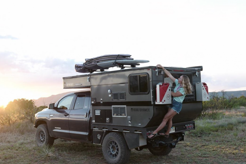 Toyota Tundra Camper with Mak climbing up onto the back. She looks as ...