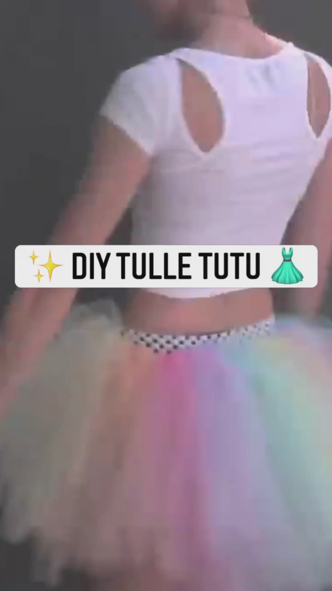 This may contain: a girl wearing a rainbow tutu with her hands on her hips and the words diy tulle tutu