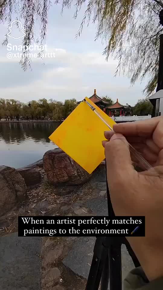 This may contain: a person holding a yellow piece of paper in their left hand with the caption, when an artist perfectly matches paintings to the environment