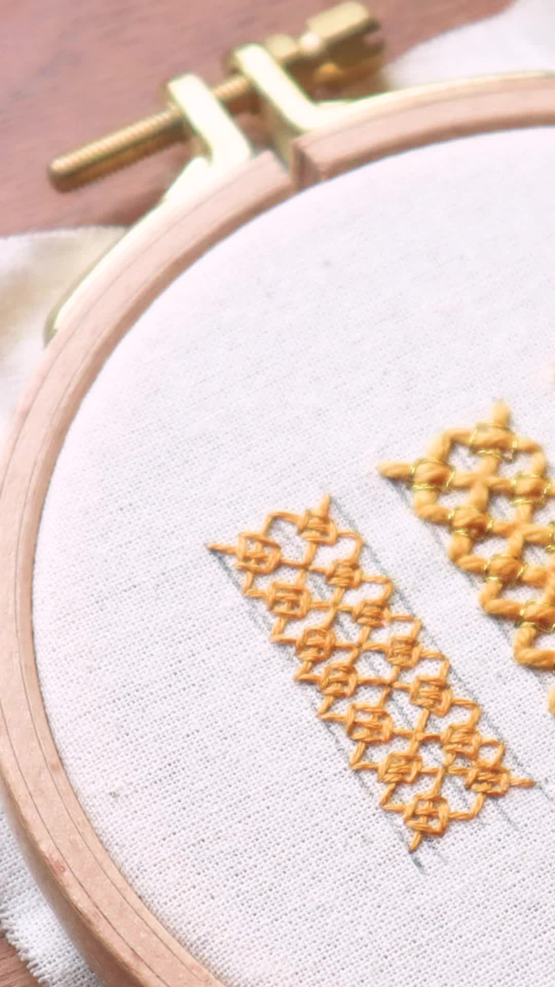 This may contain: a close up of a cross stitch pattern on a piece of cloth with scissors in the background