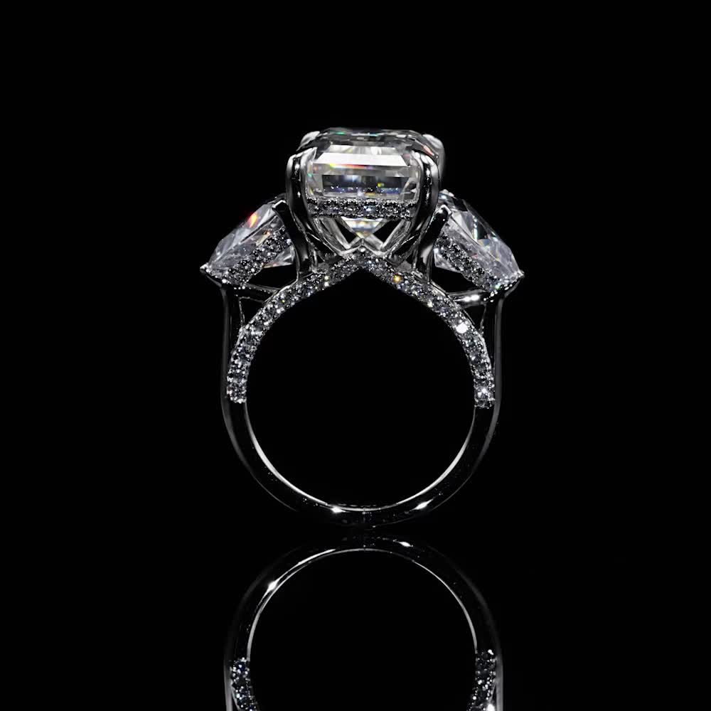 This may contain: a diamond ring with three stones on it's side and the center stone is surrounded by diamonds