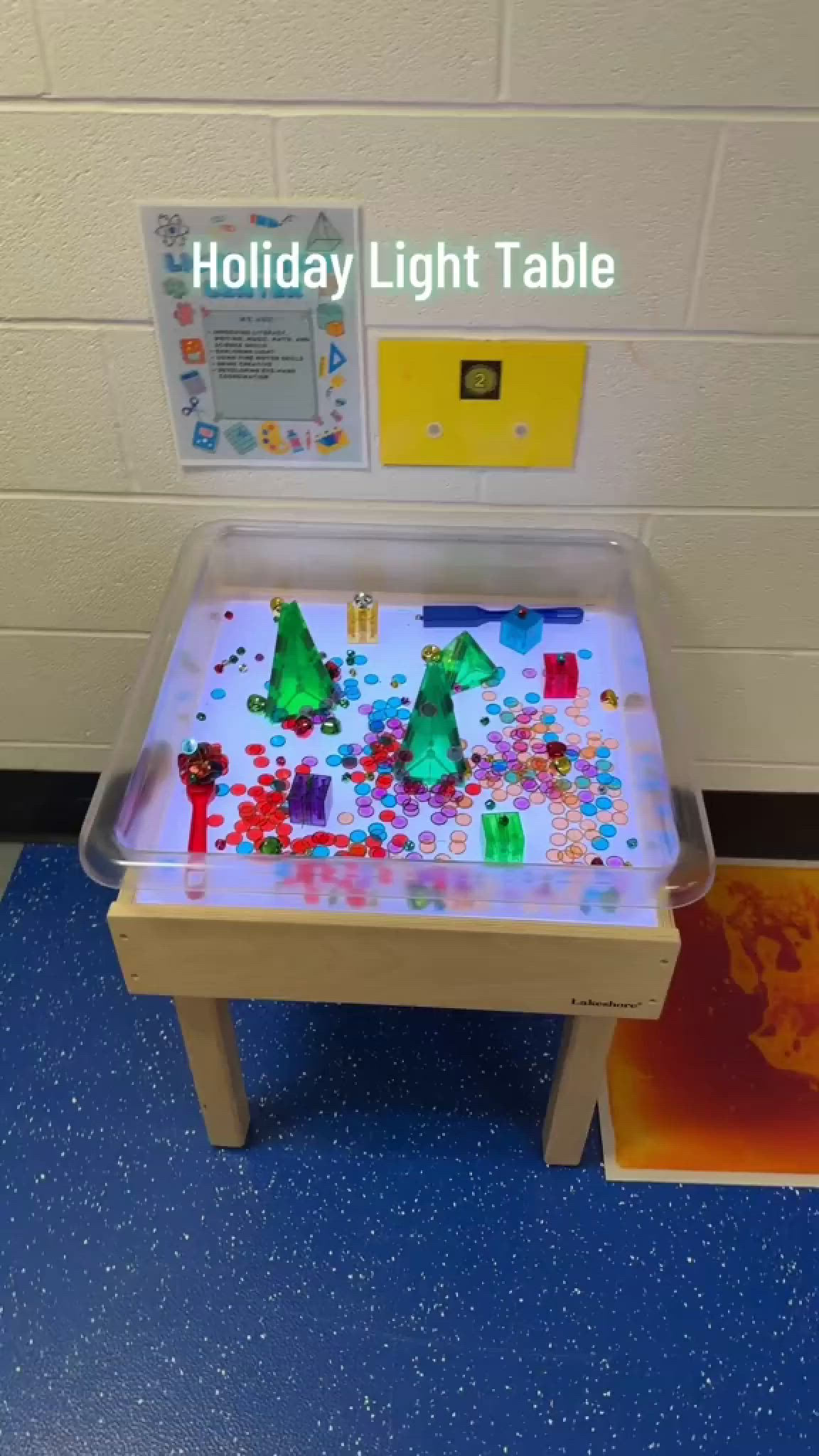 This may contain: a child's play table with colored paper on it and the words holiday light table