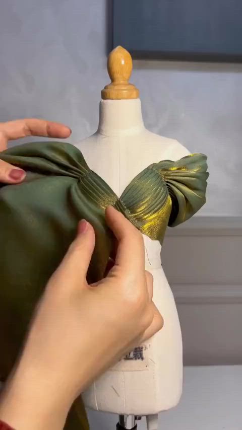 This may contain: a person is sewing on a mannequin's dummy with a green bow