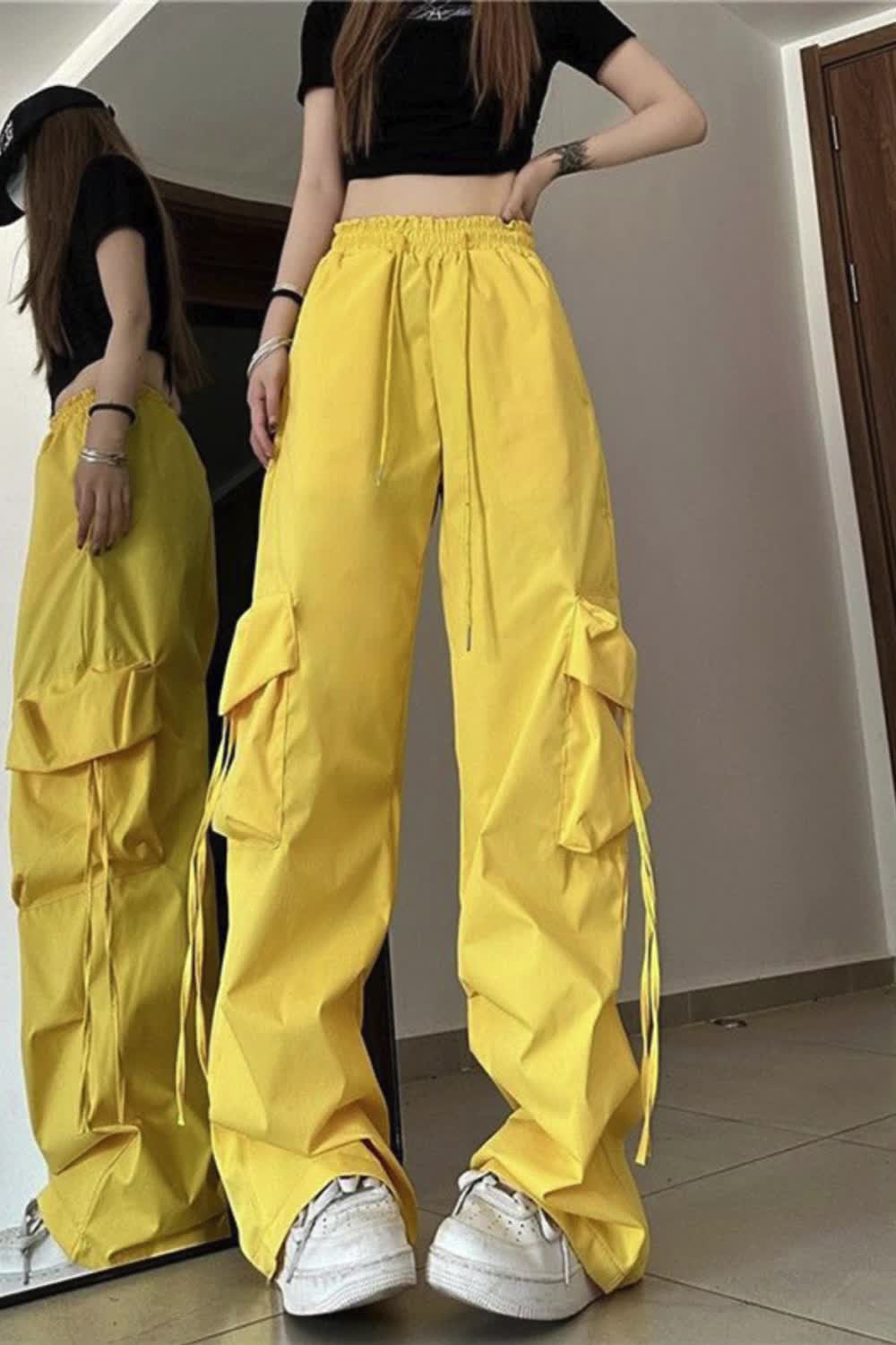 This contains: Upgrade your streetwear game with these Cargo Pants for Women! Featuring a high waist, big pockets, and lace-up design, these pants offer both style and practicality. Loose and comfortable, they are perfect for any casual occasion. Get that Y2K hip hop look effortlessly!