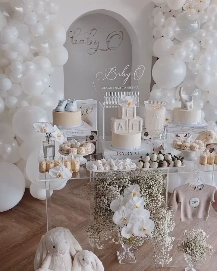 This may contain: a baby shower with white balloons and decorations