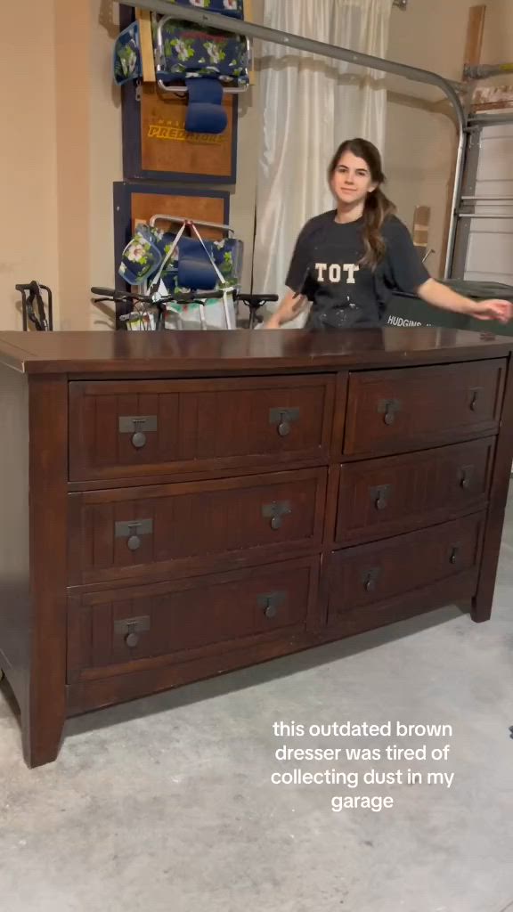 This may contain: a woman sitting on top of a dresser next to a wall with words above it