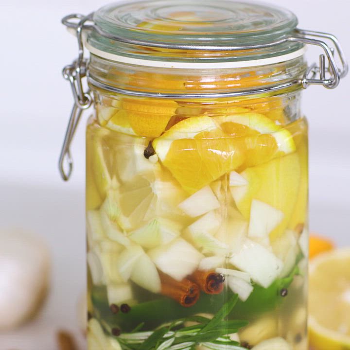 This may contain: a jar filled with sliced lemons and other ingredients to make fire - cider tonic