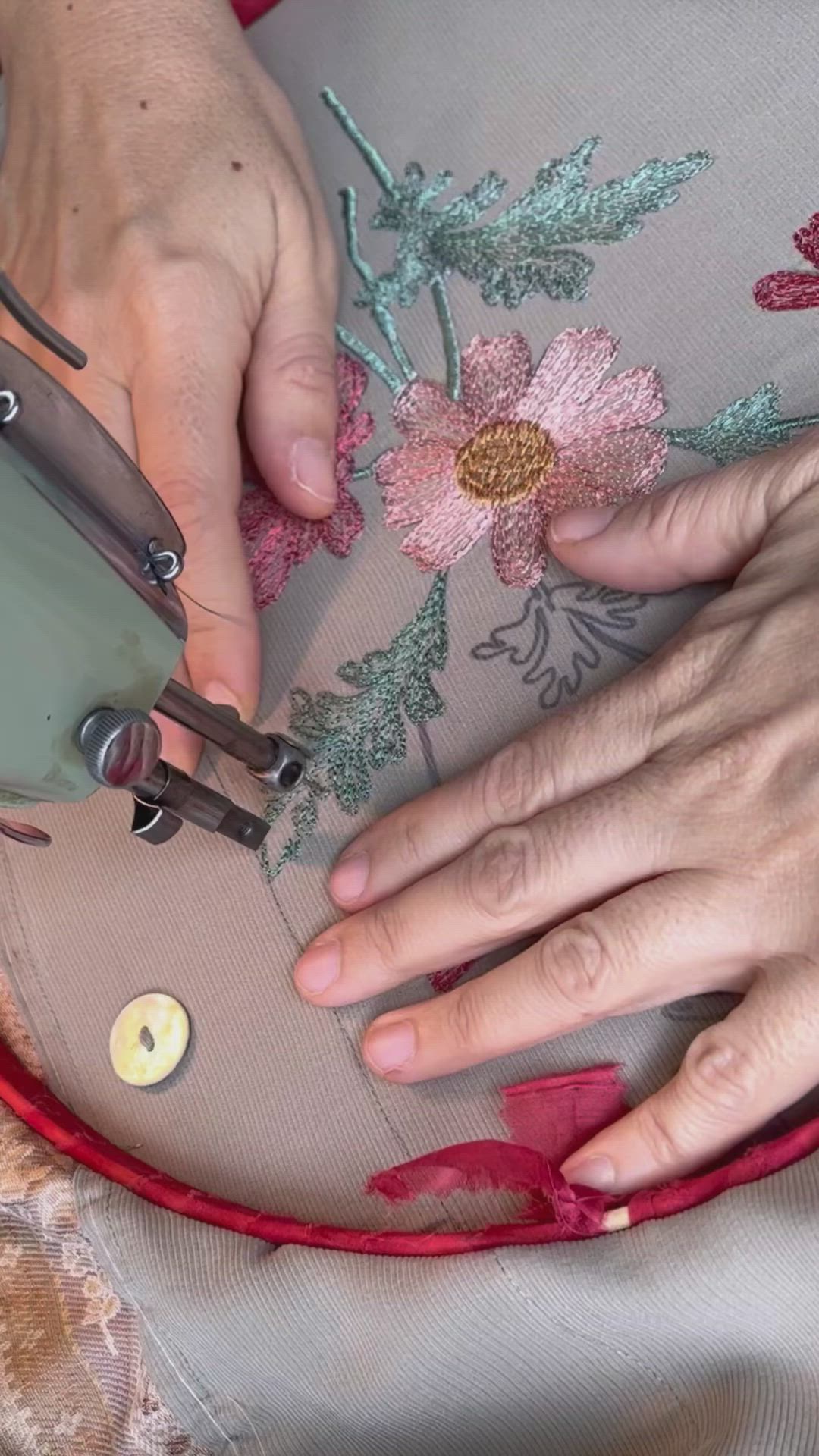 This may contain: the woman is using scissors to sew on her pregnant belly with floral fabric and buttons