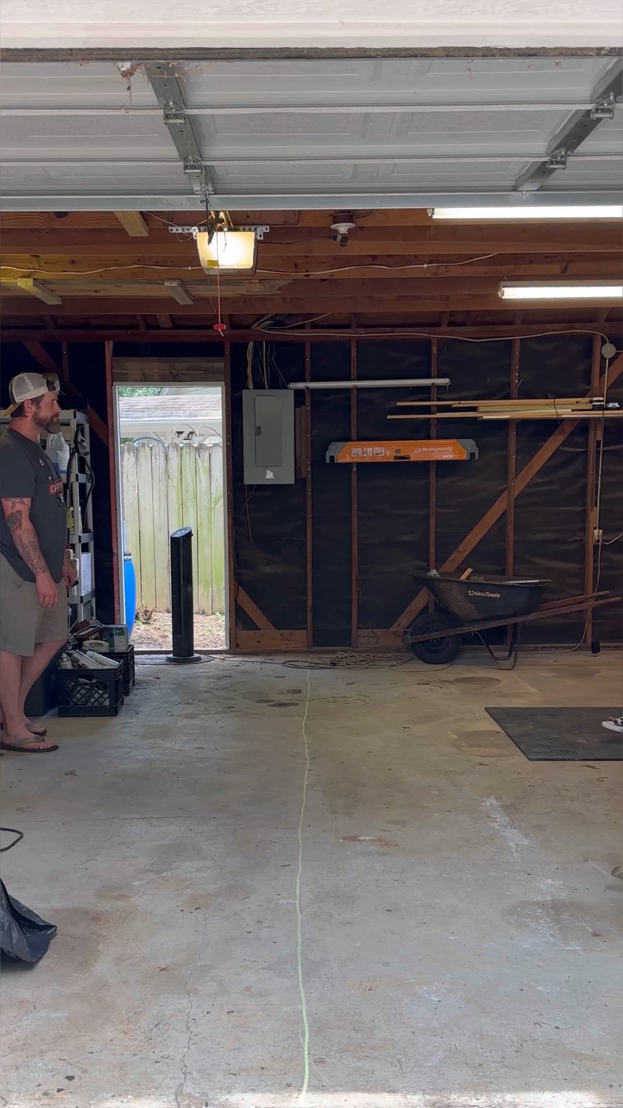 This may contain: two men are working on an unfinished garage