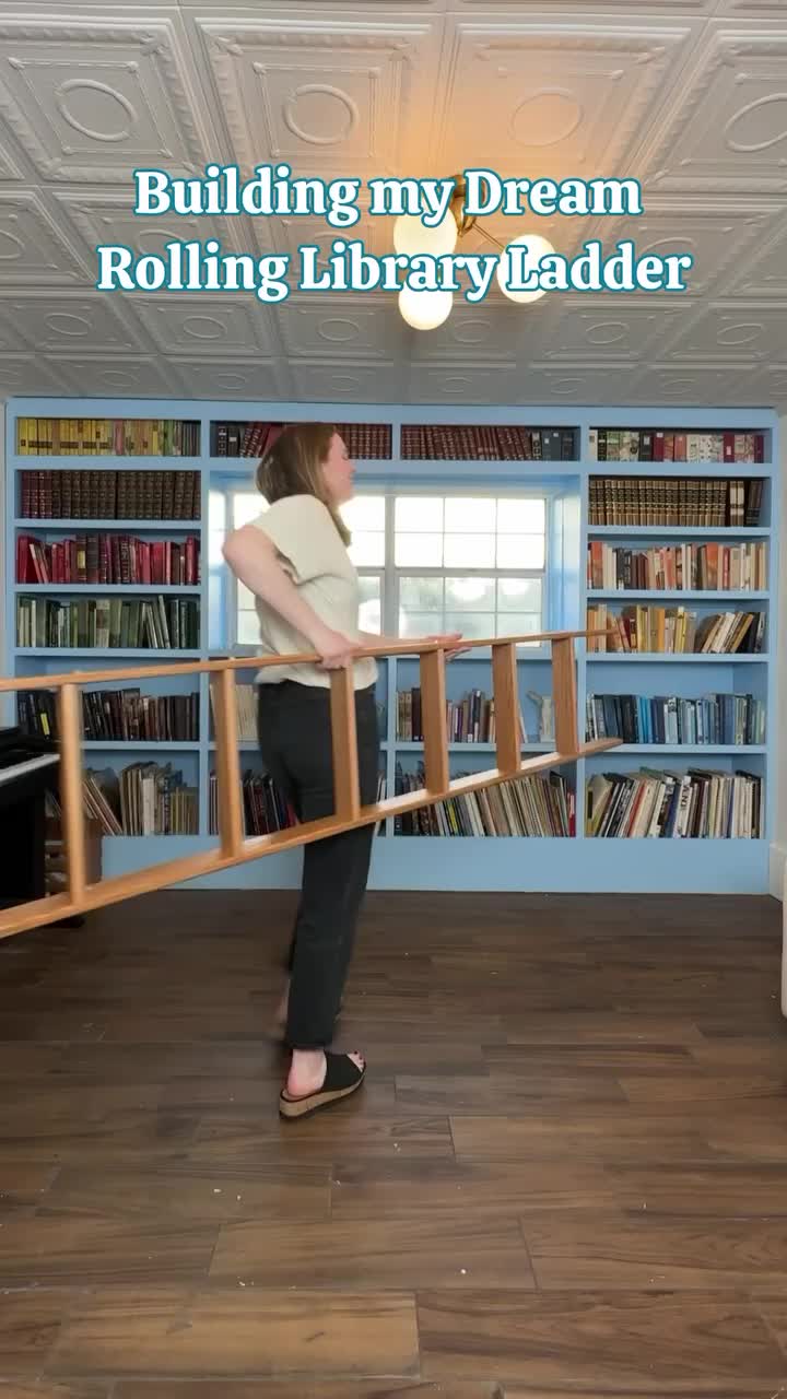 This may contain: a ladder leaning up against a bookshelf in a room with blue walls and shelves filled with books