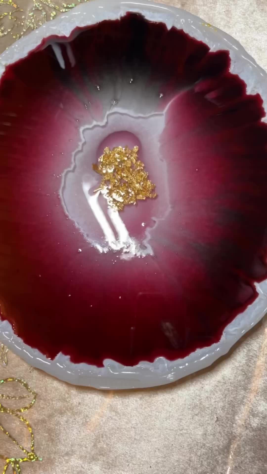 This may contain: a red and white bowl with gold flakes on it