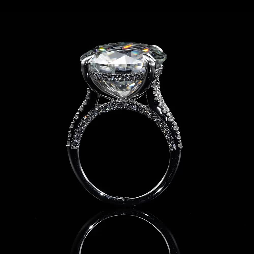 This may contain: a diamond ring on a black surface with reflection in the middle and side stones around it