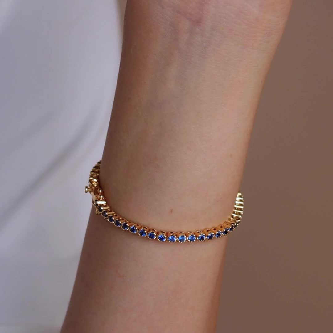 Make a shimmering statement with our Blue Diamond Tennis Bracelet. Elegant and dainty, it adds the perfect bold, finishing touch to your outfit for special occasions like anniversaries or weddings. A minimalist accessory sure to shine and a dazzling symbol of “something blue” for brides. Finish/Material: 18K Gold Over Brass ∙ White Gold Over Brass Clasp: Box clasp and side prong closure Featuring a ~3mm Tennis Bracelet with half CZ Sapphire and half CZ Diamond stones Model showcases a romantic, 