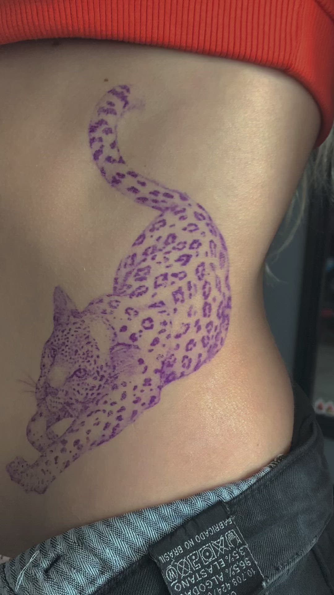 This may contain: a woman's stomach with a tattoo of a cheetah on the side