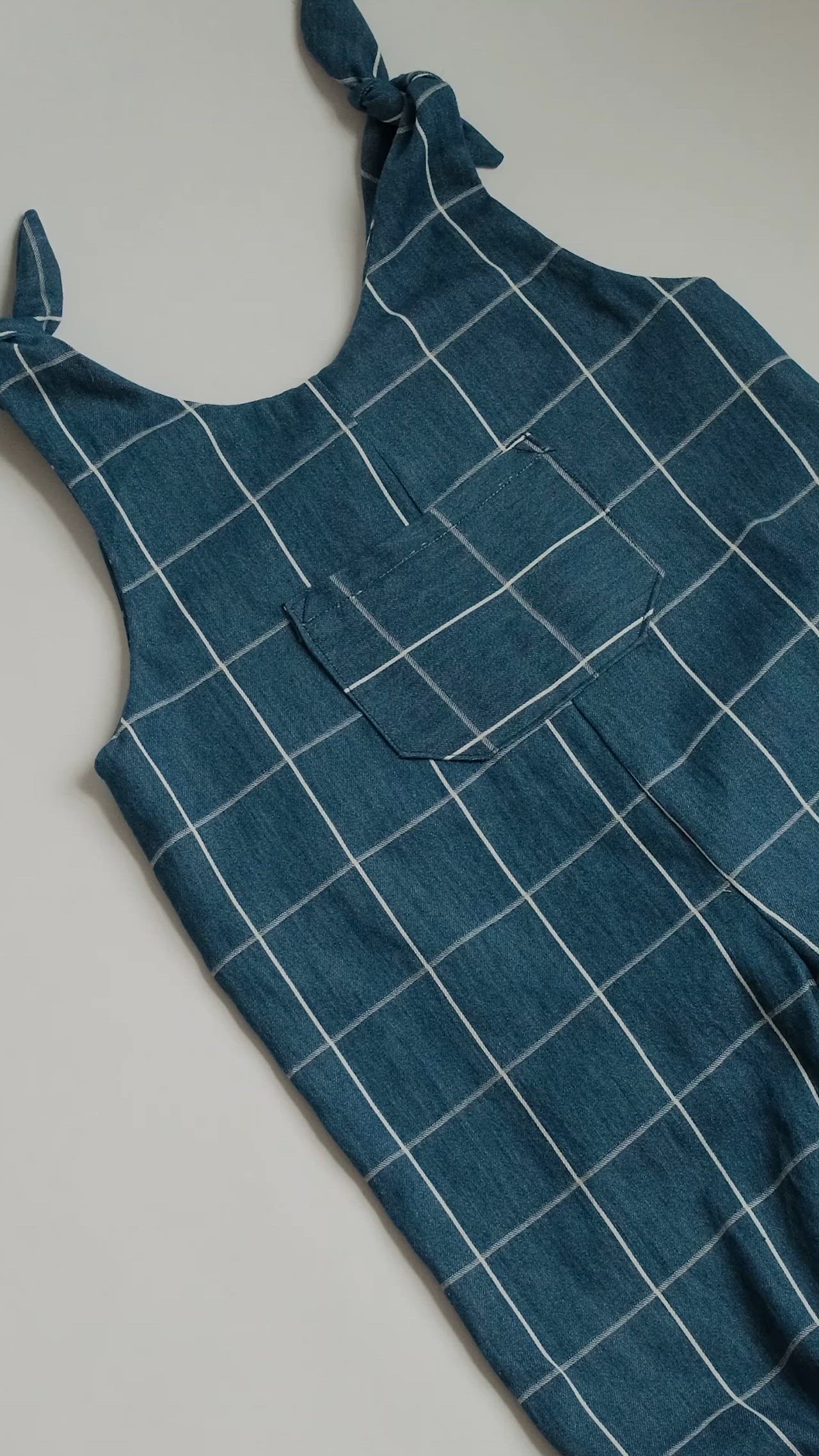 This may contain: an apron made out of blue material with white squares