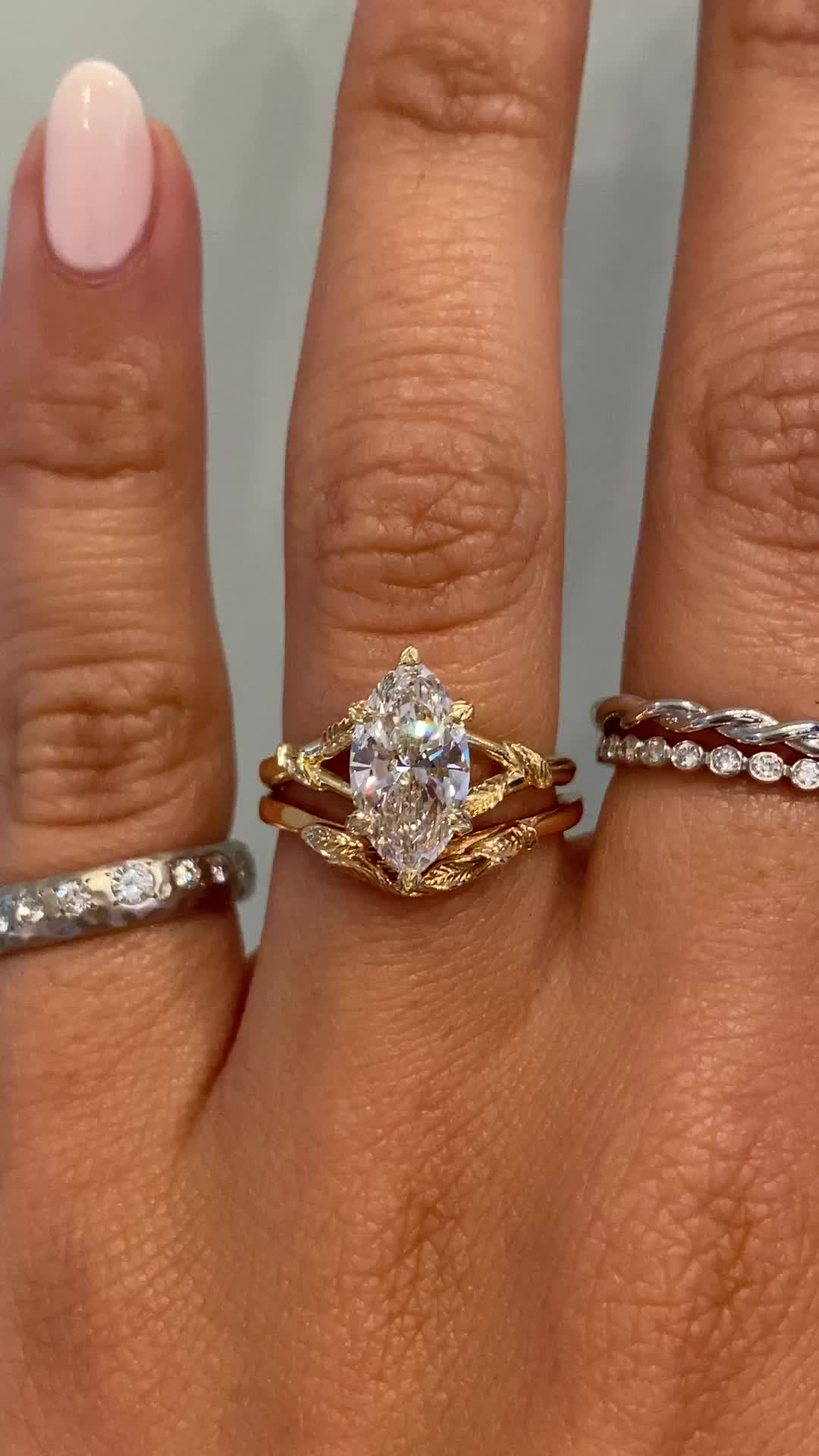 This may contain: a woman's hand with three different rings on it and one has a diamond in the middle