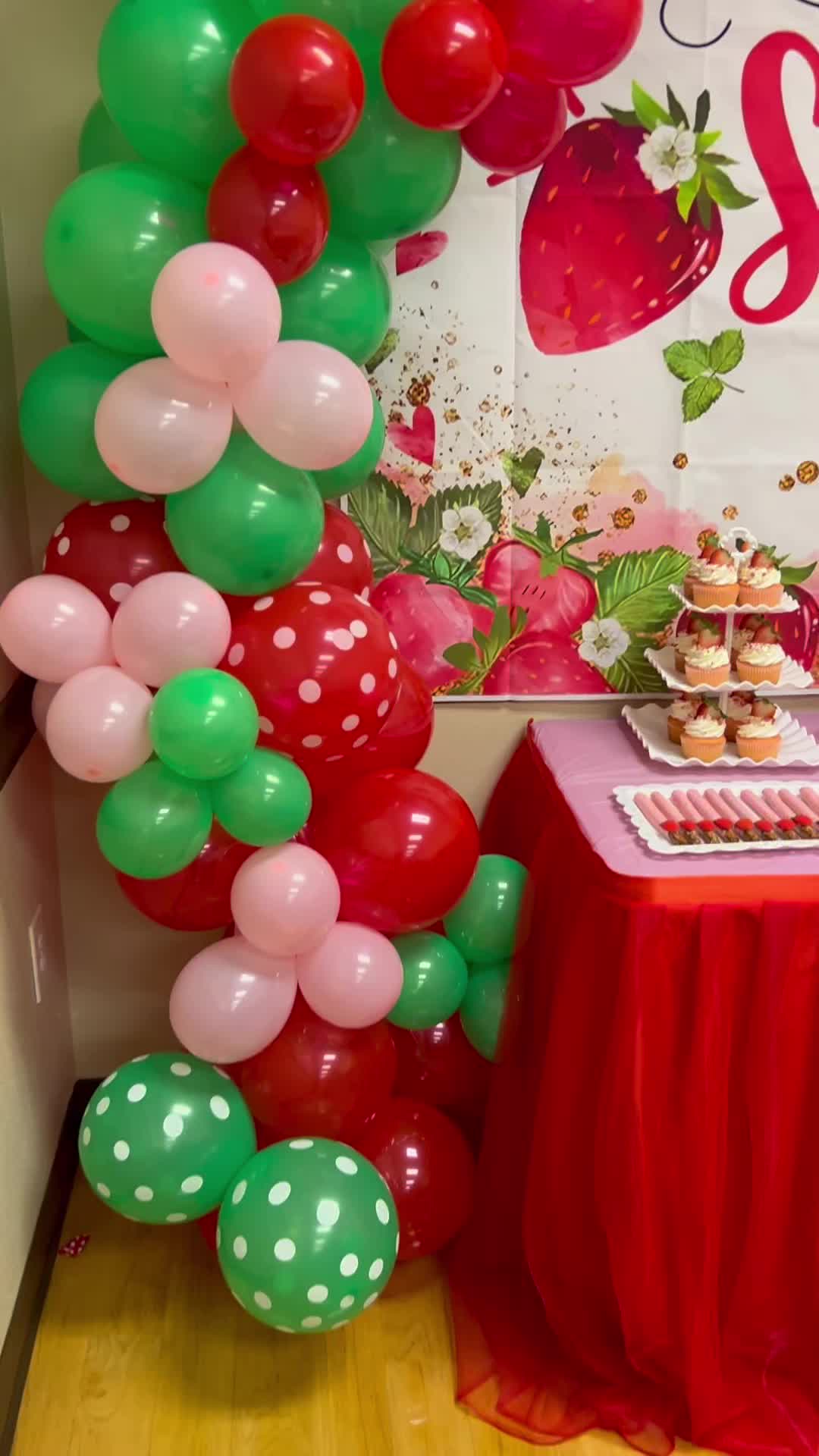 This may contain: a table topped with balloons and cupcakes next to a sign that says strawberry shortcakes